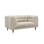 A modern two-seater loveseat sofa upholstered in a textured light beige fabric, featuring tufted button detailing on the backrest and seat, with tapered dark wood legs and gold metal tips, shown against a plain white background.