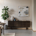 Modern living room with a walnut sideboard, decorative items, and abstract art.