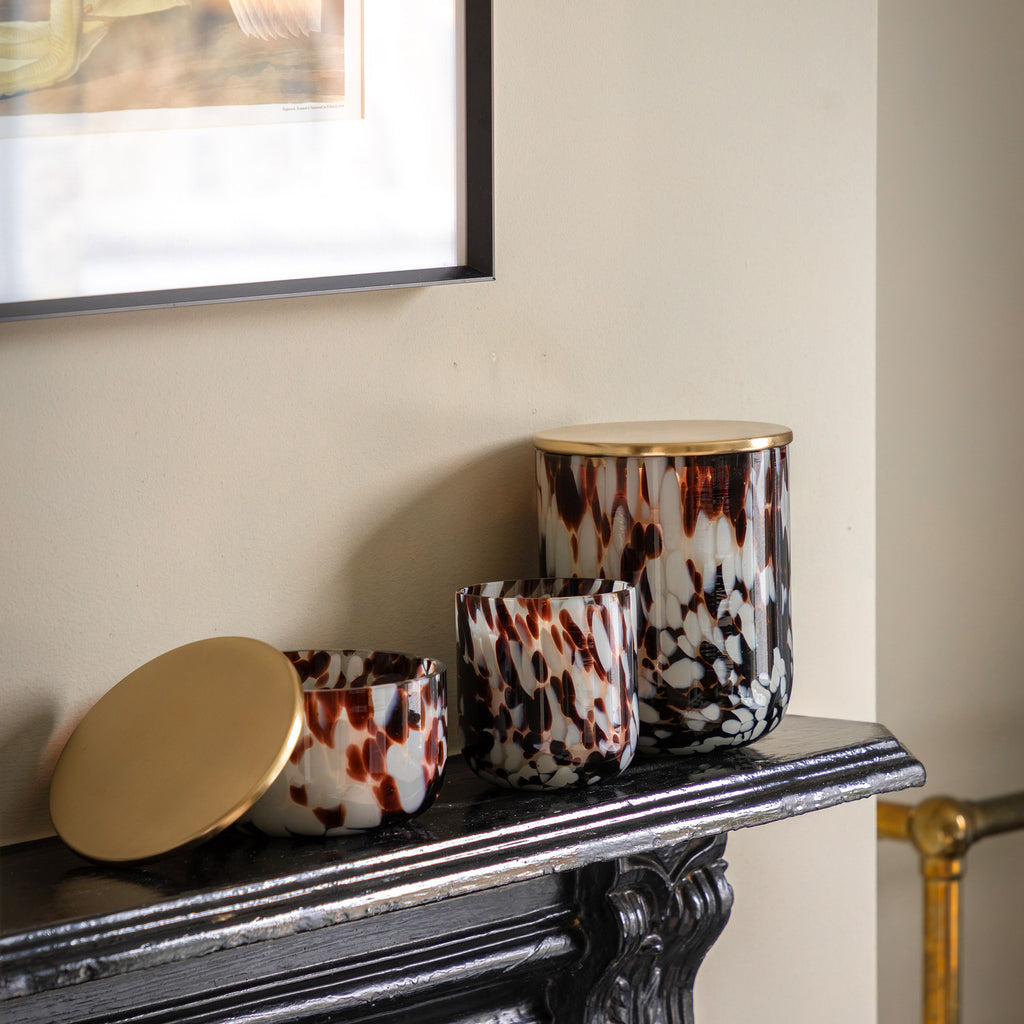 Decorative vases with a tortoiseshell pattern on a mantelpiece.