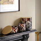 Decorative vases with a tortoiseshell pattern on a mantelpiece.
