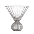 Clear glass martini glass with ribbed design on a white background