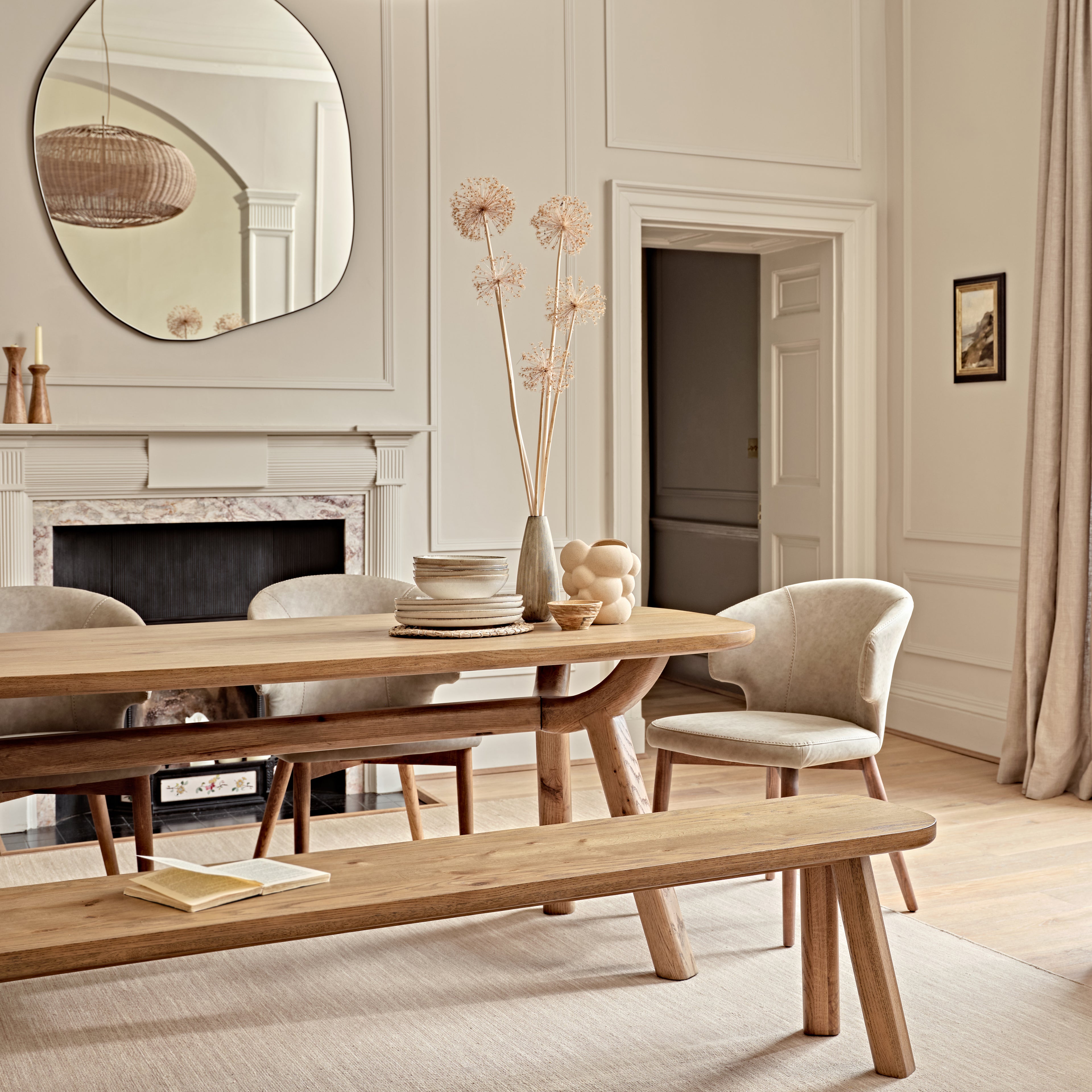 Dining room with wooden table, chairs, and bench in a well-lit room.