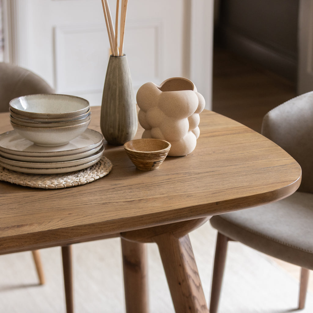 Wooden table with ceramic bowls and a vase in a minimalistic setting