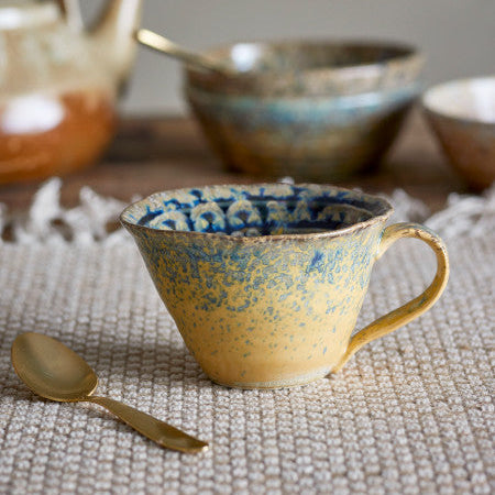 Two-tone blue and yellow cup with vibrant design for everyday use.