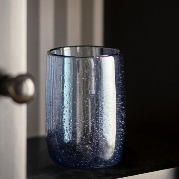 Elegant blue drinking glass on neutral background