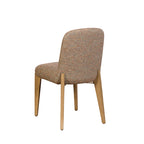 A modern dining chair with a textured, multi-colored tweed upholstery in beige, brown, and orange tones, supported by four tapered light wood legs, shown from a three-quarter angle against a plain white background.