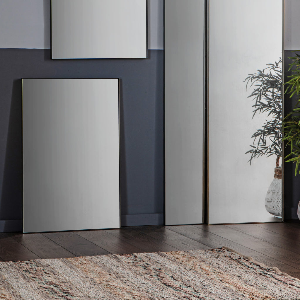 Minimalist bronze rectangle mirror hanging in contemporary living room