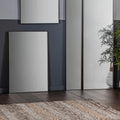 Minimalist bronze rectangle mirror hanging in contemporary living room
