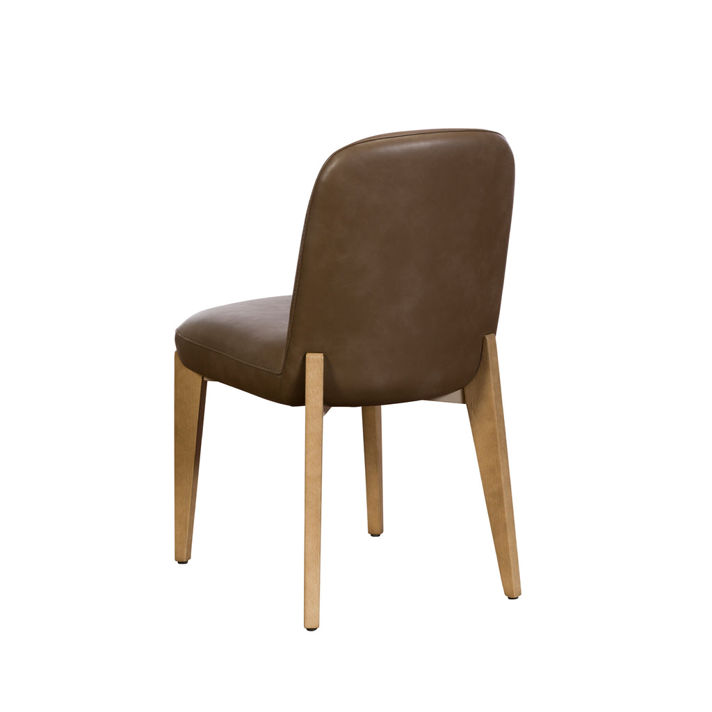 A dining chair with a brown faux-leather upholstered seat and backrest, supported by four tapered light natural wood legs, shown from a three-quarters angle on a white background.