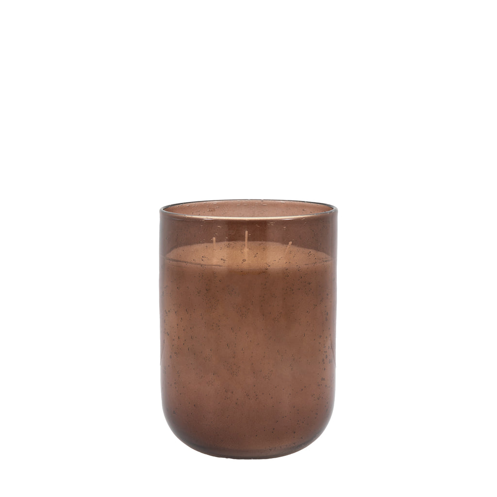 Tall large brown candle placed in living room setting