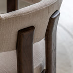 Close-up of a chair with natural fabric and wooden legs on a blurred background