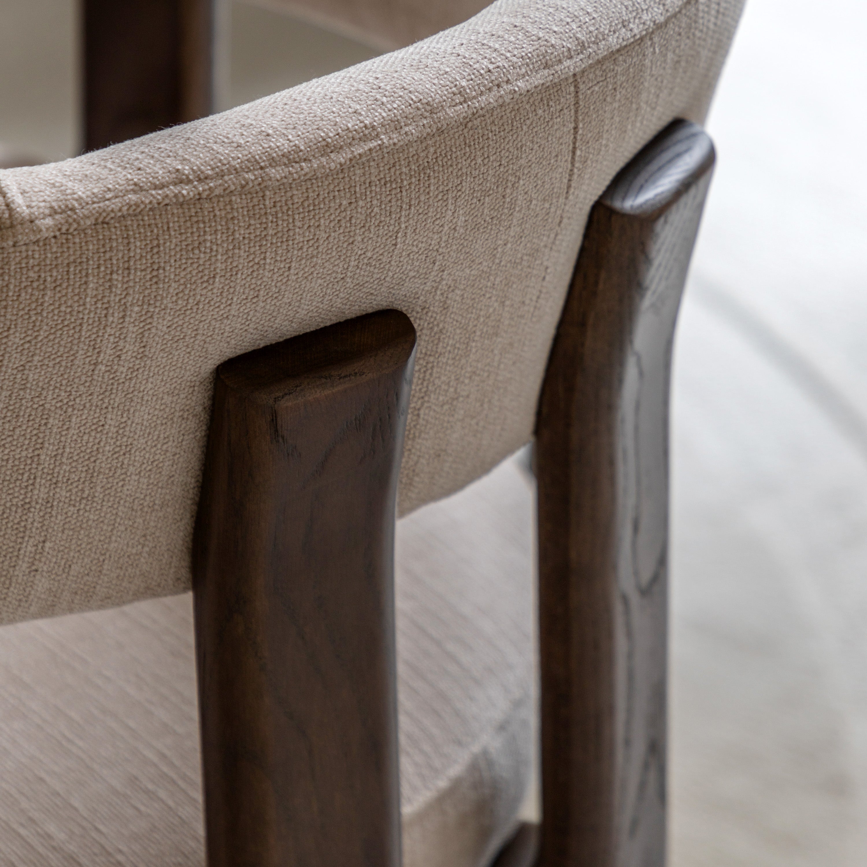 Close-up of a chair with natural fabric and wooden legs on a blurred background