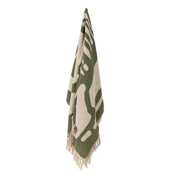 Green and white patterned throw with tassels on a white background
