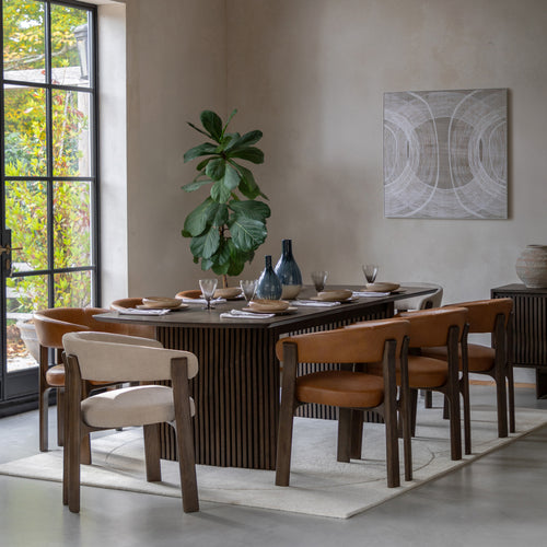 Dining room with a Walnut table and chairs, a plant, and abstract art on the wall.