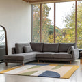 Gray Eva sectional sofa left hand facing in a room with large windows and a colorful rug.