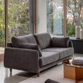 Gray sofa in a modern living room with large windows.