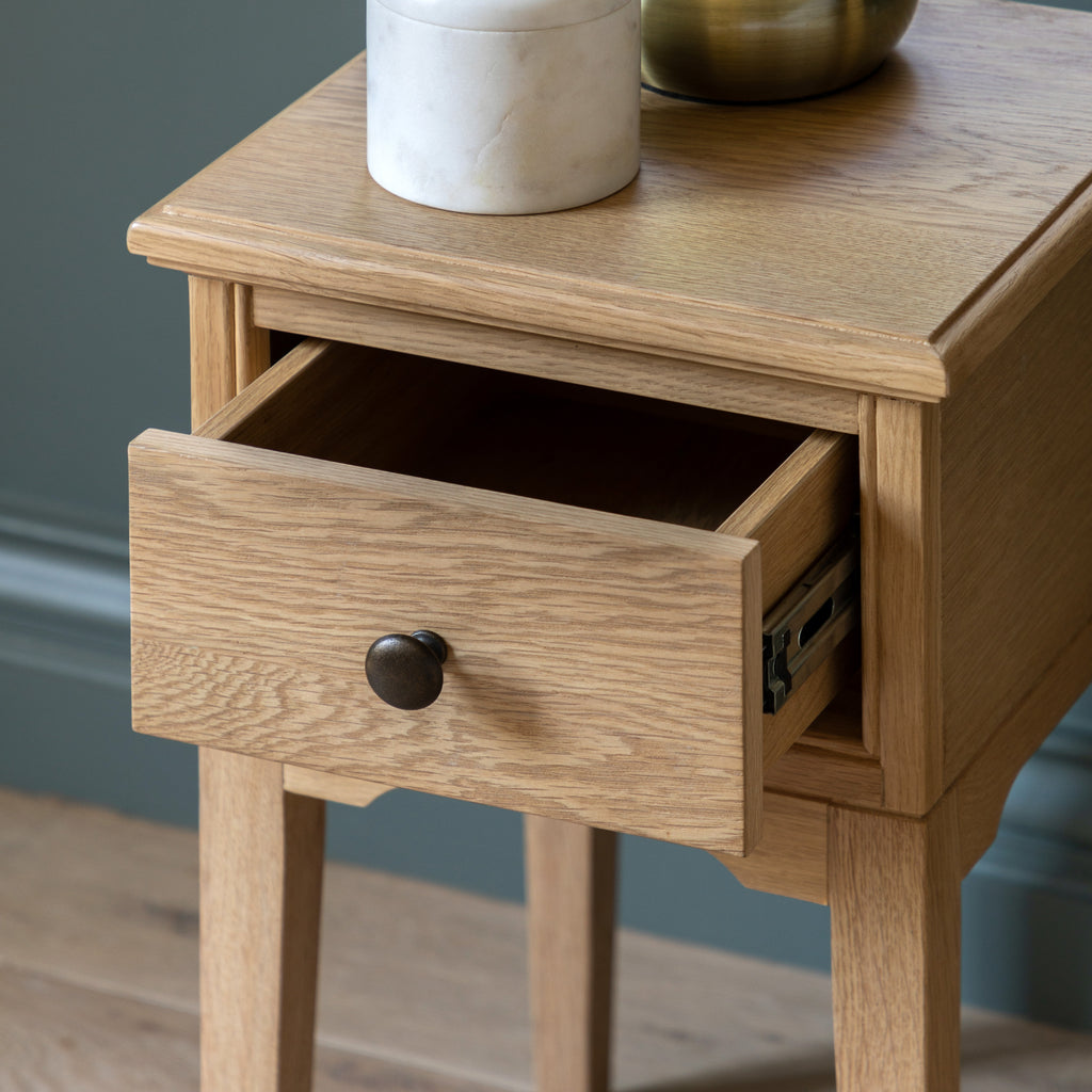 Wooden bedside table with a drawer, showing an open drawer.