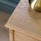 Detail photo of a wooden side table with a brass bowl on top