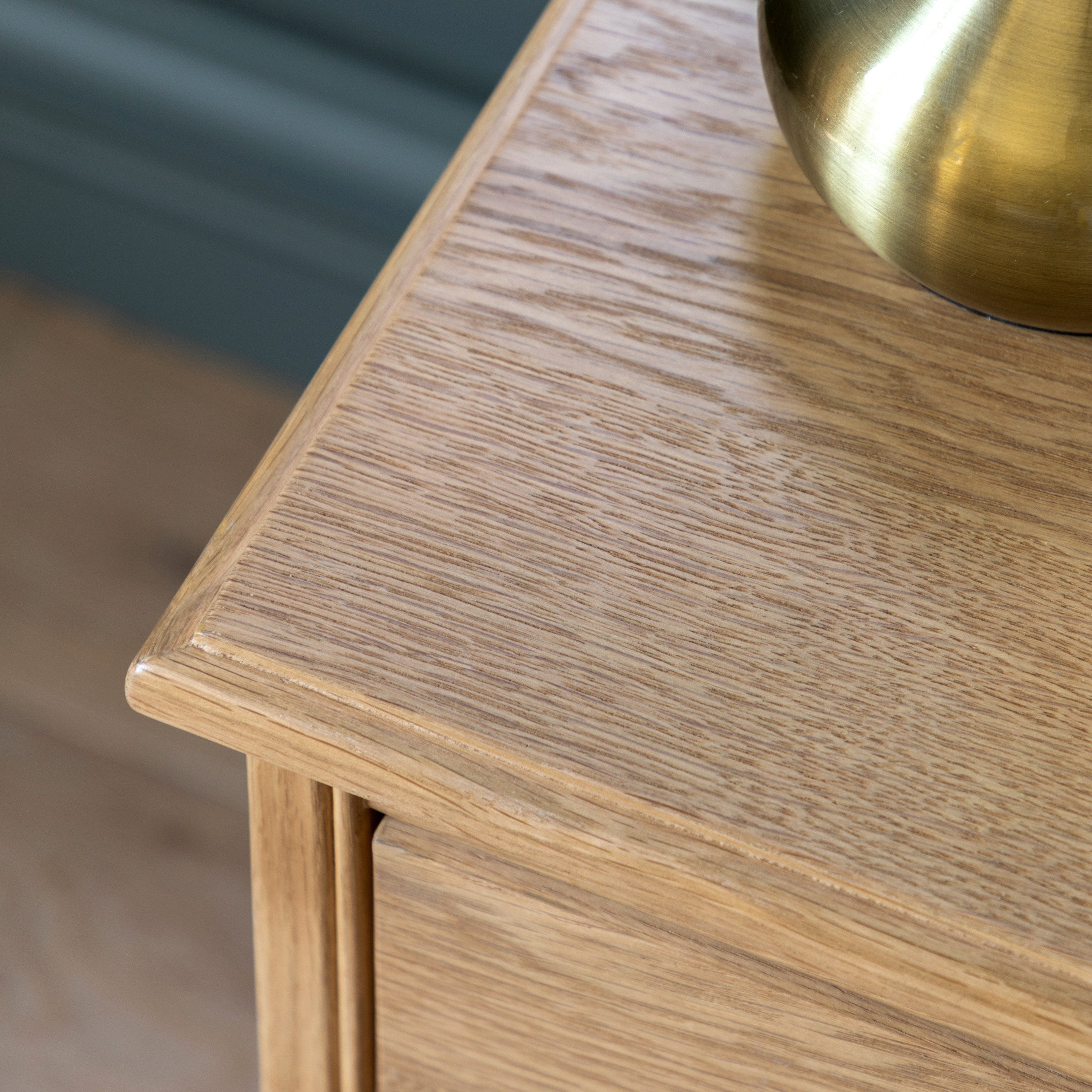 Detail photo of a wooden side table with a brass bowl on top