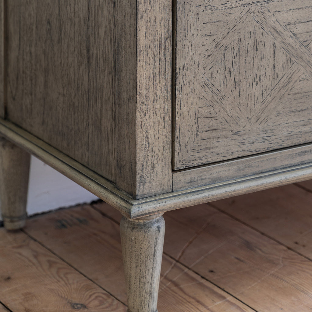 Side angle of Faringdon 7 Drawer Chest showcasing its height, proportions, and the detailed craftsmanship of the turned feet and frame.