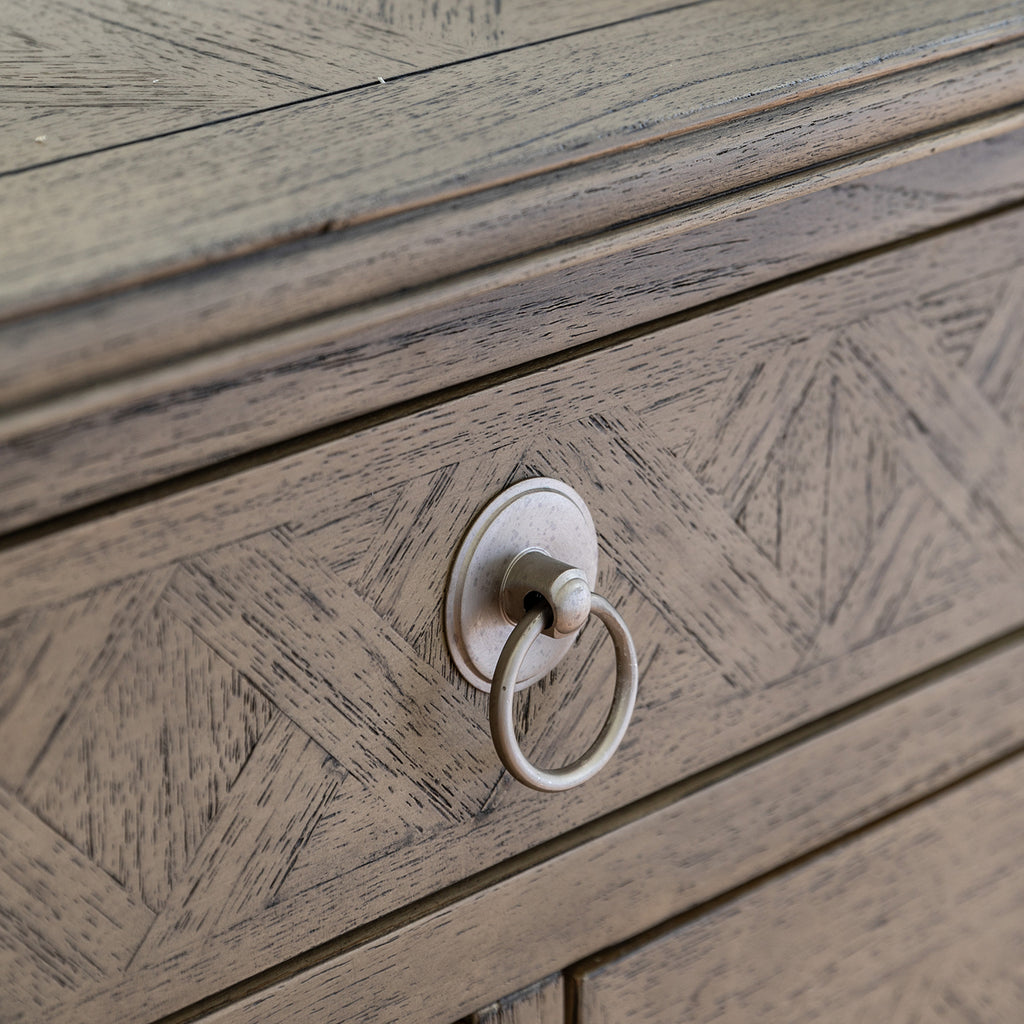 Detail view of Faringdon Chest's drawer hardware, showing the brass handles that complement the natural wood finish and add a touch of elegance