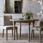 Faringdon Round Dining Table in a styled dining room setting with chairs, demonstrating its proportions and how it fits in a complete dining arrangement