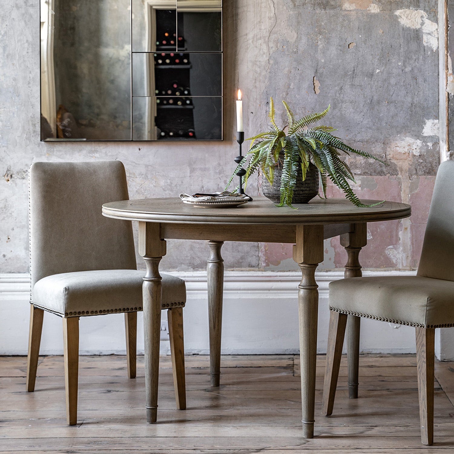 Faringdon Round Dining Table in a styled dining room setting with chairs, demonstrating its proportions and how it fits in a complete dining arrangement