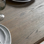 Detail shot of the Wallingford Extending Dining Table's wood finish, showing the texture and warm tones of the natural wood.