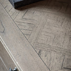 Close-up detail of Faringdon Sideboard's parquet wood pattern top, highlighting the natural grain variations and craftsmanship of the inlaid design