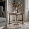 Wallingford Side Table in a styled living room setting next to a sofa, demonstrating its height and functionality for drinks, books, or decorative items