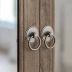 Detail view of Faringdon Wardrobe's door hardware, showing the brass handles and hinges that complement the natural wood finish