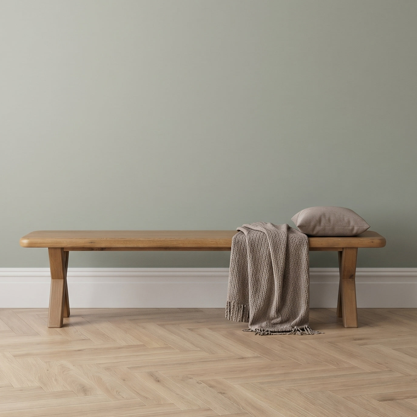 Wooden bench with a blanket and pillow against a plain wall.