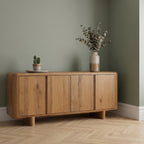 Oak wide sideboard with decorative items against a green wall