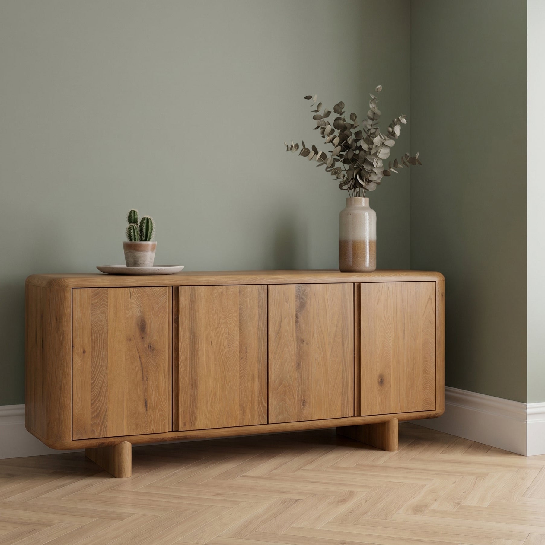 Oak wide sideboard with decorative items against a green wall