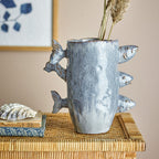 Decorative vase with fish designs on a wicker surface