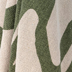 Textured green throw folded on an armchair, sofa creating a cosy and stylish home accent