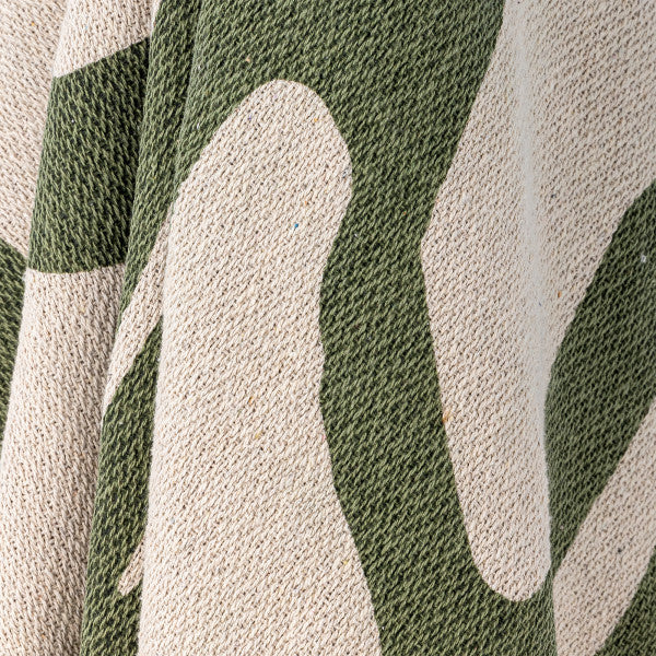 Textured green throw folded on an armchair, sofa creating a cosy and stylish home accent