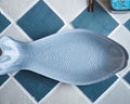 Blue fish-shaped bath mat on a tiled bathroom floor
