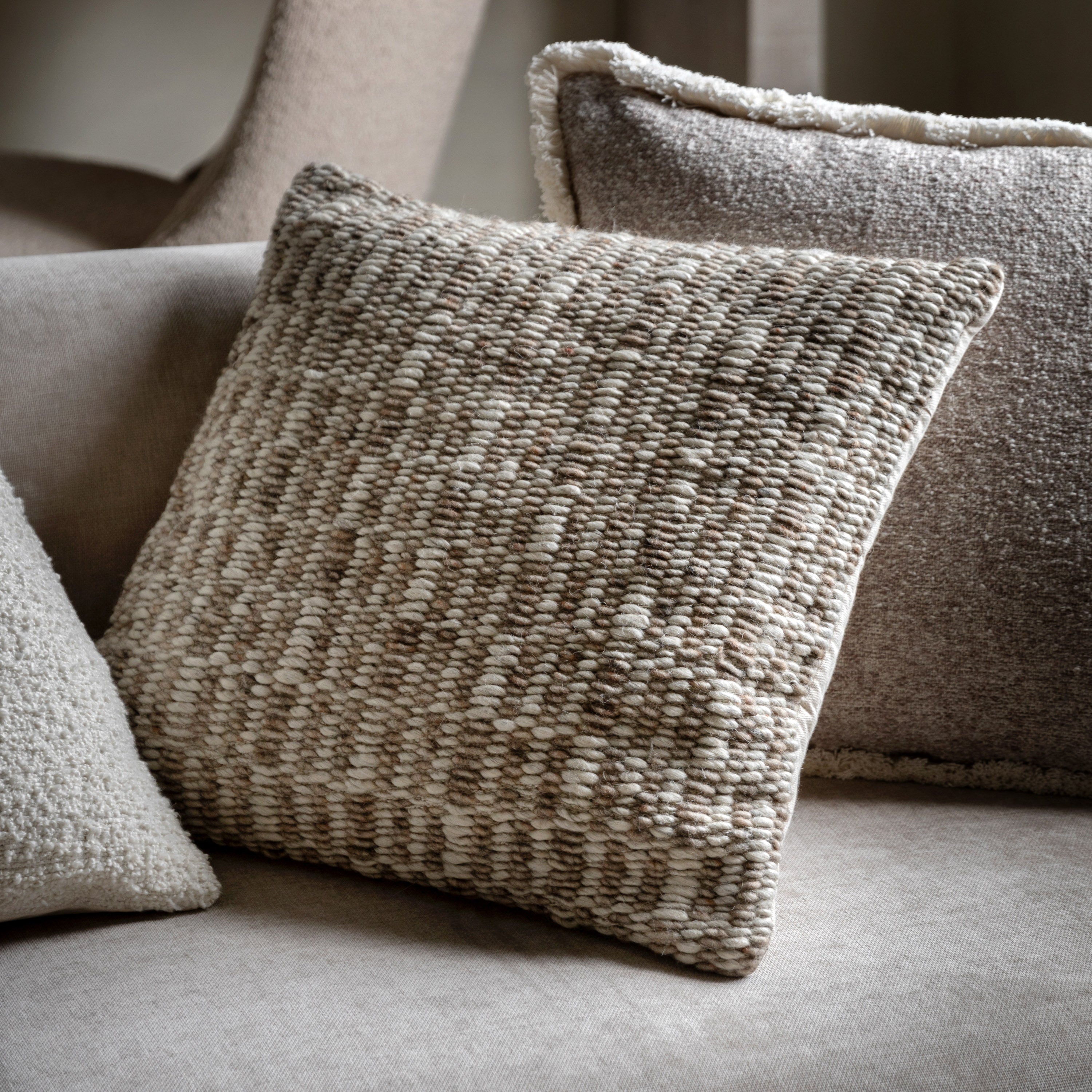 Textured pillows on a sofa with a neutral colour palette