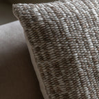 Close-up of a textured natural pillow on a neutral background