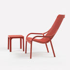 Red net lounge chair and net 40 table set on a white background