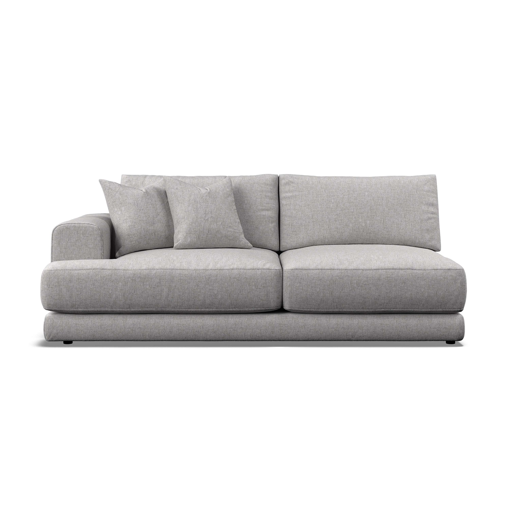 A modern low-profile sofa in light gray textured fabric, featuring two matching throw pillows, shown against a plain white background.