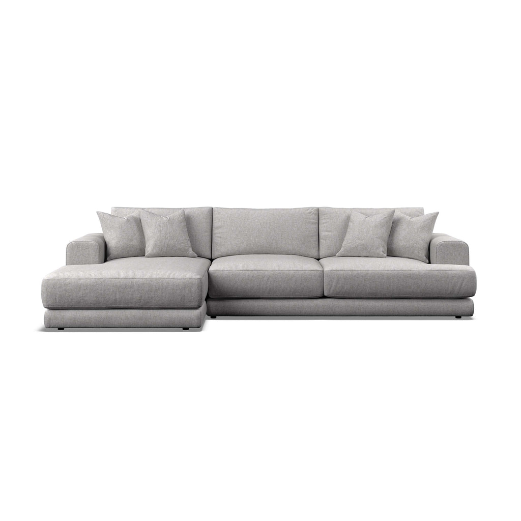 A modern light gray fabric sectional sofa with a left-facing chaise lounge and multiple matching throw pillows, shown against a plain white - background.