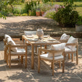 Beautiful acacia wood garden table complete with 6 comfy chairs on a patio