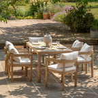 Beautiful acacia wood garden table complete with 6 comfy chairs on a patio