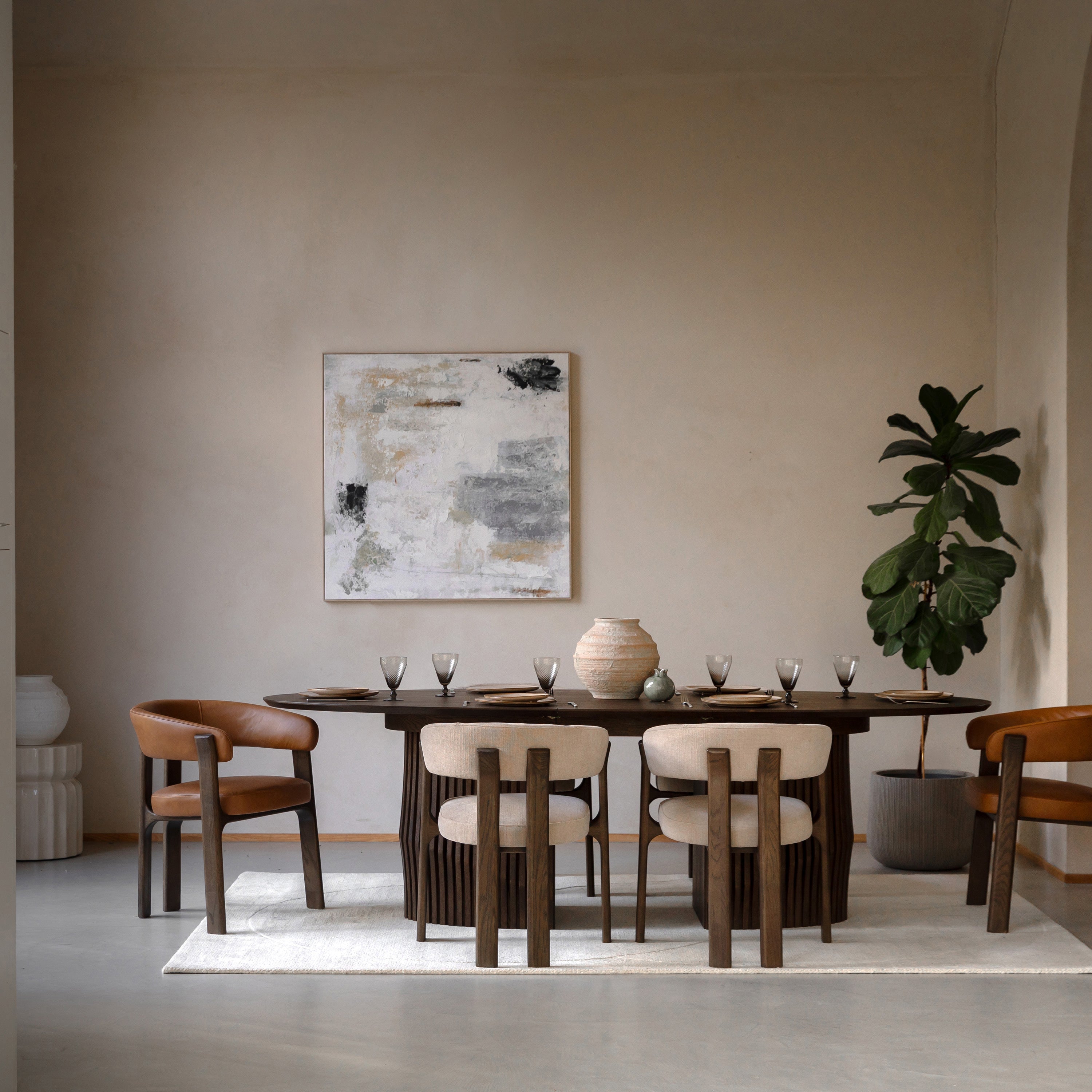 Dining room with Walnut table and chairs, abstract painting on the wall, and a plant.