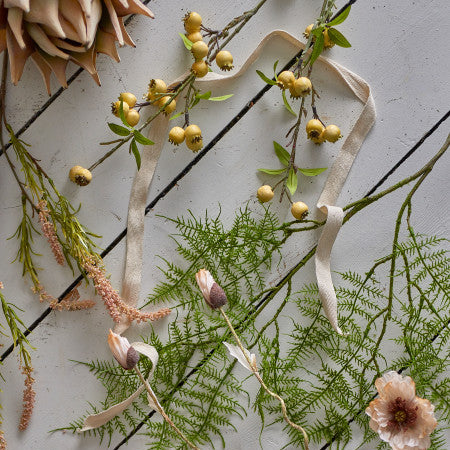 Decorative arrangement of flowers and ribbons on a textured surface