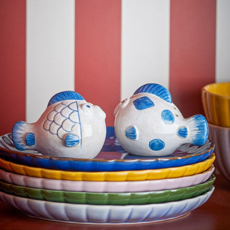 Set of 2 fish salt and pepper shakers sitting on a plate