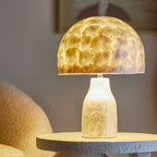 Table lamp with a textured glass shade on a concrete base in a room setting.