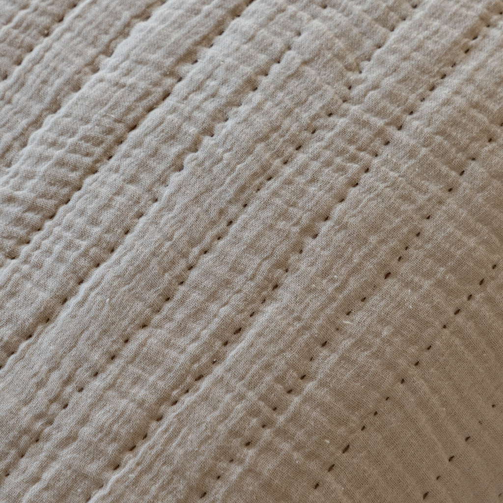 Close-up of taupe textured fabric with a diamond pattern